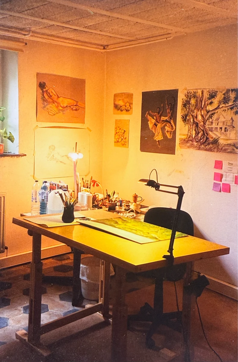 Sharon’s art studio in Brussels, with paintings on the walls, brushes and a work table.